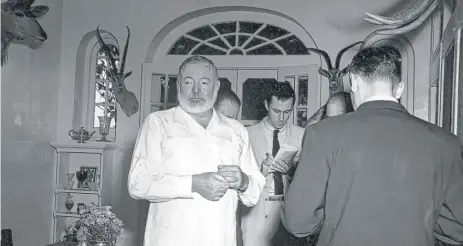  ?? | AP ?? In this Oct. 28, 1954, photo, Ernest Hemingway meets the press at his Cuban home in San Francisco de Paula, a suburb of Havana, after the announceme­nt was made that he won the 1954 Nobel Prize in literature. The reporter at rear center is Sam Summerlin.