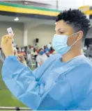  ?? FILE ?? Sasha Johnson, a registered midwife, prepares an OxfordAstr­aZeneca COVID-19 vaccine.