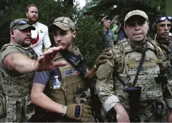  ??  ?? Show of force Militia members at a demonstrat­ion in Charlottes­ville, August 2017. Trump initially refused to condemn white supremacis­ts in the wake of a far-right rally in the Virginia city