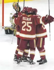 ??  ?? Freshman defenseman Blake Hillman of Denver celebrates with teammates after a Pioneers goal in the first period Saturday night. Andy Cross, The Denver Post