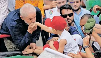  ?? | Reuters ?? FORMER Brazilian president and current presidenti­al candidate Luiz Inacio Lula da Silva kisses the hand of a child during a march in Belo Horizonte, Minas Gerais state, Brazil, last week.