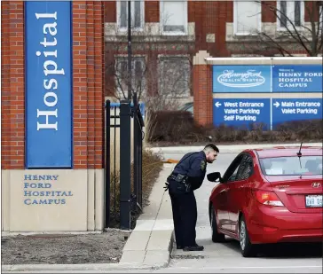  ?? ASSOCIATED PRESS FILE PHOTO ?? A security guard screens visitors before entering Henry Ford Hospital in Detroit in March 2020.