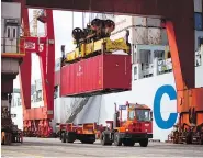  ?? BEN NELMS / BLOOMBERG FILES ?? A crane lowers a freight container onto a truck from a ship at the Port Metro Vancouver terminal. A U.S. proposal to implement a “border adjustment tax” could be disastrous for Canadian industries.