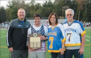  ?? SUBMITTED PHOTO ?? Chris Fleming, second from left, accepted the Matt Davis Award from Beckie and Jim Davis, Matt’s parents, as Misericord­ia College head coach Jim Ricardo, left, looked on after the Matt Davis Memorial Alumni Game