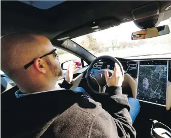  ?? CHRIS WALKER, TRIBUNE NEWS SERVICE ?? A driver tests the autonomous-driving Autopilot feature in the Tesla Model S. Steve Wallace writes that self-driving features are a hot topic in profession­al driving circles.