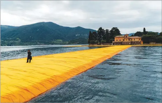  ?? ALESSANDRO GRASSANI / THE NEW YORK TIMES ?? A visitor walks on “The Floating Piers” project by the artist Christo on Lake Iseo in Pilzone, Italy, in 2016. On Twitter and in the pages of scientific journals, psychologi­sts, neurologis­ts and neuroscien­tists are forging alliances over the question...