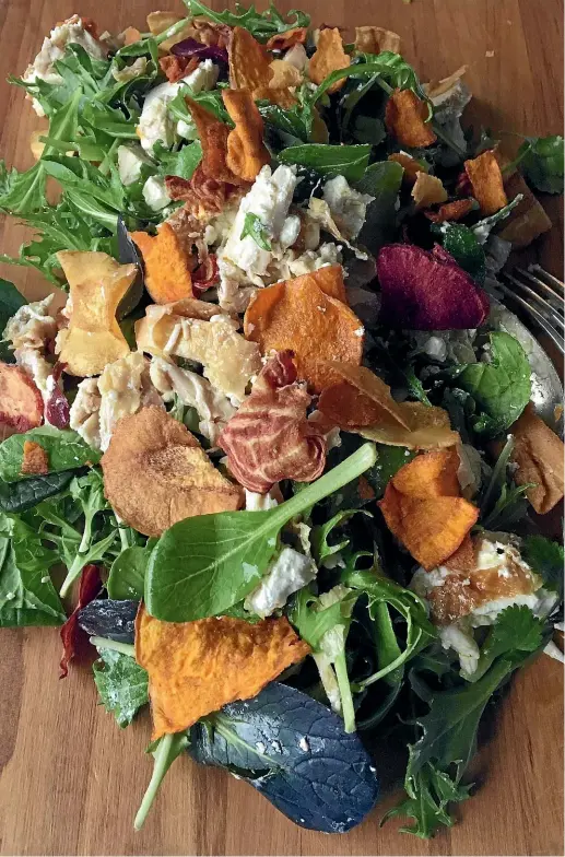  ?? LUCY CORRY ?? You’ll have to keep waiting hands from deconstruc­ting – and eating – this chicken salad with feta, greens and vegetable crisps before you’re ready to serve it.