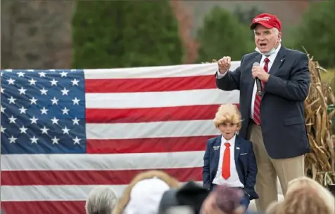  ?? Emily Matthews/Post-Gazette ?? Gino Benford, 7, of Johnstown, dressed as President Donald Trump, stands on a stage with U.S. Rep. Mike Kelly, R-Butler, during a presidenti­al campaign rally on Oct. 28 in Portersvil­le. Mr. Kelly insists that the legal battle over the results for the presidenti­al election is not over. “We really believe that we were harmed,” he said.