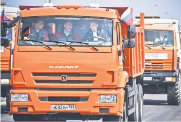  ??  ?? Putin drives a constructi­on truck across the new 19 kilometres road-and-rail Crimean Bridge over the Kerch Strait linking mainland Russia to Moscow-annexed Crimea during the opening ceremony. — AFP photos