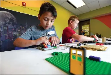  ?? NWA Democrat-Gazette/J.T. WAMPLER ?? Sawyer Hanson, 8, (left) and Cole Steinlage, 12, both of Bentonvill­e, work Monday on their creations at Lego camp at the Bentonvill­e Community Center. Children were creating a comic book using Lego scenes and background­s. The camp continues this week...