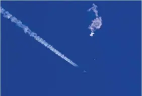  ?? CHAD FISH VIA AP ?? The remnants of a large balloon drift above the Atlantic Ocean on Saturday, just off the coast of South Carolina with a fighter jet and its contrail seen below it.