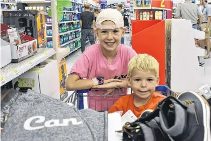  ?? MICHAEL ROBAR/THE GUARDIAN ?? Hannah and Landon Birt posed with their goodies while back-to-school shopping with their parents Kim and John on Sunday.