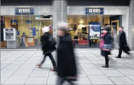  ?? PHOTO: EPA ?? Pedestrian­s pass a Royal Bank of Scotland (RBS) bank branch in central London yesterday. RBS reported a loss for 2014 for the seventh year in a row.