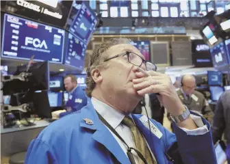  ?? AP PHOTO ?? FEELING THE HEAT: A trader on the floor of the New York Stock Exchange watches as markets opened sharply lower yesterday.