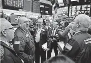  ?? [AP PHOTO] ?? Specialist Peter Giacchi, left, calls out prices Tuesday before Spotify’s IPO on the floor of the New York Stock Exchange.