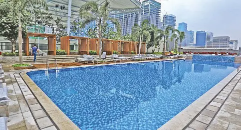  ??  ?? The breathtaki­ng view from the poolside includes two covered tennis courts on one side.