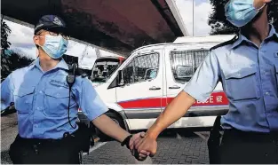  ?? REUTERS ?? Police officers escort a prison van which is carrying Tong Ying-kit, the first person charged under the new national security law, as he leaves West Kowloon Magistrate­s' Courts, in Hong Kong, China July 6, 2020.