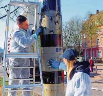  ?? FOTOS: BECKER & BREDEL ?? Jede Menge Federn blieben in der Metzer Straße (l.) und der Egon-Reinert-Straße in Saarbrücke­n zurück: Stadt-Mitarbeite­r reinigten gestern die verschmutz­ten Radar-Säulen.