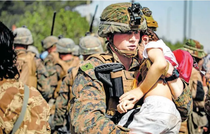  ?? Foto: Efe ?? Un soldado de Estados Unidos lleva en brazos a una niña durante el proceso de evacuación en el aeropuerto de Kabul, Afganistán.