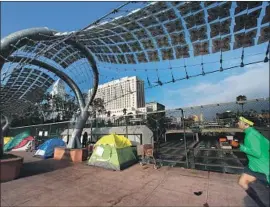  ?? Genaro Molina Los Angeles Times ?? A JOGGER runs past a row of tent shelters on Main Street above the 101 Freeway in downtown Los Angeles. The city is the homeless capital of the nation.