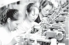  ??  ?? Employees working on a production line of clothes for export at a factory in Xiayi county, in Shangqiu in China’s central Henan province. Key economic readings in China showed investment slumping to a record low for the first seven months of the year as retail sales slowed, pointing to weakness in the world’s second largest economy. — AFP photo