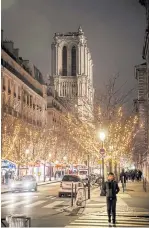  ??  ?? A street with Christmas lights, and Notre Dame cathedral in the background.