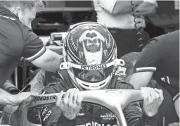  ?? PAUL CHIASSON/THE CANADIAN PRESS VIA AP ?? Mercedes Team driver Lewis Hamilton, of Britain, slips into his car during the first practice session at the Formula One Canadian Grand Prix on Friday in Montreal.