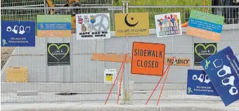  ?? JIM RANKIN TORONTO STAR ?? Signs adorn fencing around constructi­on of a permanent memorial for the Afzaal family, at the site of the truck attack in London, Ont. Monday marks the one-year anniversar­y of the hate-motivated killings.