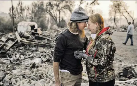  ?? Marcus Yam Los Angeles Times ?? RYAN SPAINHOWER embraces his wife, Kimberly, amid the remains of their home that the Camp fire destroyed in Paradise, Calif.