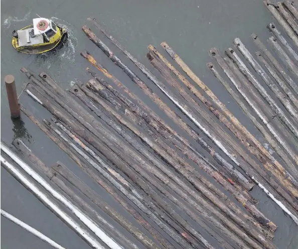  ?? DARRYL DYCK/THE CANADIAN PRESS ?? A worker in a boat moves logs on the Fraser River in Delta, B.C. Forestry firms across Canada fear thousands of sawmill jobs are threatened if the U.S. slaps duties on softwood, which one analyst predicted could be a “shock and awe” level of 30 to 40...