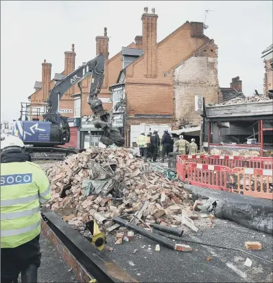  ??  ?? Emergency services sift through the wreckage of the former supermarke­t in Hinckley Road, Leicester.
