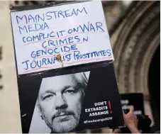  ?? — AFP photo ?? A supporter of Assange holding up a placard outside The Royal Courts of Justice, Britain’s High Court, in central London.