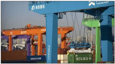  ?? (AP) ?? A crane lifts a shipping container at an automated container port in Tianjin, China, in January.