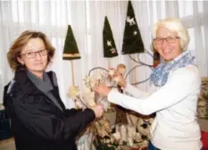  ?? Foto: Sonja Diller ?? Edeltraud Stegmiller (l.) aus Neusäß kam zum Stöbern ins Langweider Rathaus und wurde fündig: die schönen Holzsterne aus Luise Kohouts Werkstatt werden bei ihr winterlich­en Charme ins Haus zaubern.