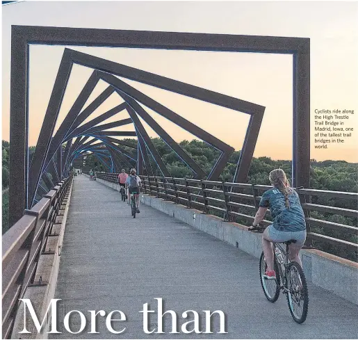  ?? KC MCGINNIS PHOTOS FOR THE WASHINGTON POST ?? Cyclists ride along the High Trestle Trail Bridge in Madrid, lowa, one of the world.