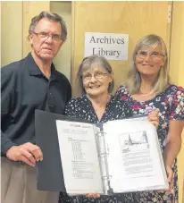  ?? SUBMITTED ?? Jack Sorensen, left, Lorna Lord and Fran Albrecht, members of the South Shore Archival Committee, show a completed copy of one of the books catalogued from the William Waddell Historical Collection.