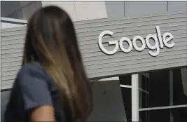  ?? JEFF CHIU — THE ASSOCIATED PRESS FILE ?? A woman walks below a Google sign on the company’s campus in Mountain View.