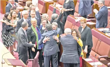  ??  ?? Senators are seen celebratin­g after the same-sex marriage bill passed the Senate in the Senate chamber at Parliament House in Canberra. — Reuters photo