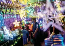  ?? ?? File photo shows people shopping for LED lights sold by traders around Jalan Tuanku Abdul Rahman in Kuala Lumpur, for Hari Raya Aidilfitri celebratio­ns.