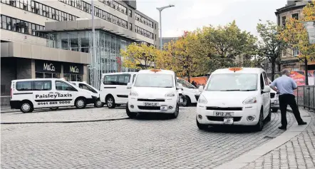  ??  ?? Pulling rank Taxi drivers wait for customers in County Square, Paisley