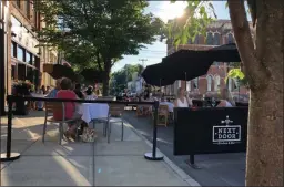  ?? ELLEN MOTTOLA PHOTO/FILE ?? Guests dine outdoors at Next Door Kitchen & Bar in downtown Ballston Spa earlier this month.