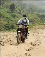  ?? ?? Bawa rides on a motorbike along a road.