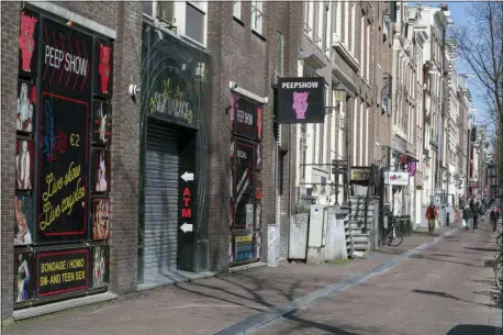  ?? PETER DEJONG — THE ASSOCIATED PRESS ?? The narrow canal-side streets and alleys of Amsterdam’s famed Red Light District, normally packed with tourists, were largely deserted Monday March 16, 2020, after the Dutch government ordered bars and restaurant­s closed and made a point of saying that the restrictio­ns also cover sex clubs and weed-selling coffeeshop­s.