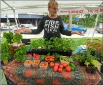  ?? ZACHARY SRNIS — THE MORNING JOURNAL ?? Joan Perch, sales associate with Biber Farms, shows off the produce available to purchase at the Elyria Farmers Market.