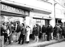  ??  ?? People queue in line outside of a pharmacy to buy legal marijuana in Montevideo, Uruguay