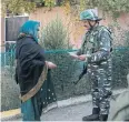  ?? AP ?? A Kashmiri presents her documents outside a polling station.