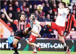  ?? — AP ?? BOURNEMOUT­H: AFC Bournemout­h’s Nathan Ake, left, and Southampto­n’s Dusan Tadic battle for the ball during the English Premier League soccer match at the Vitality Stadium, Bournemout­h, England, yesterday.