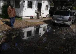  ?? ?? A man says this street near his home has been flooded for months. Communitie­s nationwide are losing trillions of gallons because of leaking infrastruc­ture.