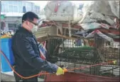  ?? LI JIANPING / FOR CHINA DAILY ?? A worker disinfects poultry cages at a market in Suichuan county, Jiangxi province, on Sunday. The county has ordered the closure of local poultry markets from Saturday to March 10.