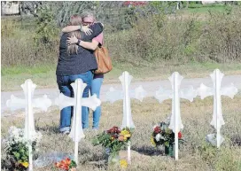  ?? [AP PHOTO] ?? Two women hug at a makeshift memorial for the First Baptist Church shooting victims Tuesday in Sutherland Springs, Texas.